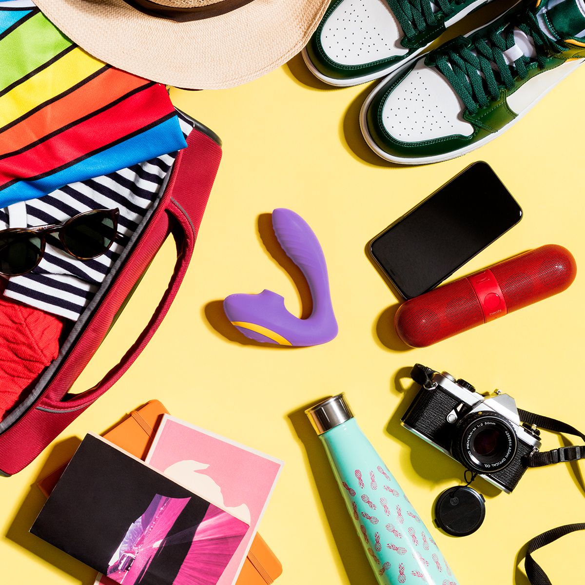 Romp Clitoral & G-Spot Stimulator, Product Beside Bag with Other Personal Novelties